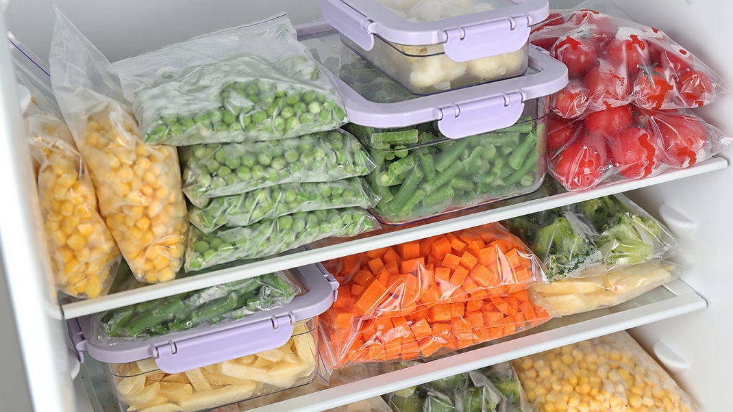 Different frozen veggies in ziploc and containers inside fridge