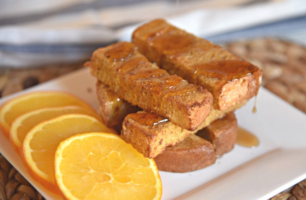 Air Fryer French Toast Sticks on a plate with orange slices