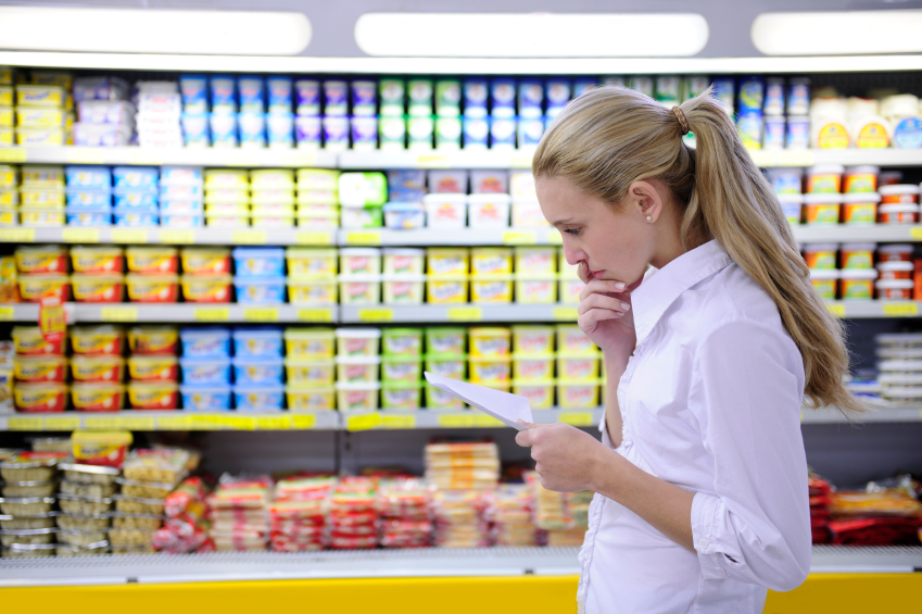 Woman looking at list at grocery store
