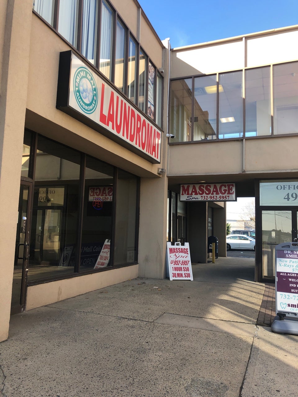 Small laundromat at mall beside massage parlor
