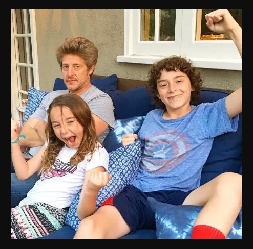 Smiling Charley and Wyatt in couch with father Jason