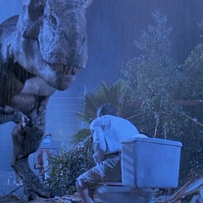CGI T. rex staring down at a man sitting on a toilet bowl in a scene from 1993 Jurassic Park