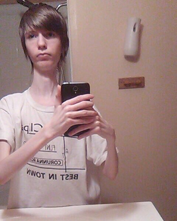 Daddy Long Neck in white T-shirt, with the words ‘best in town’ taking a bathroom mirror selfie