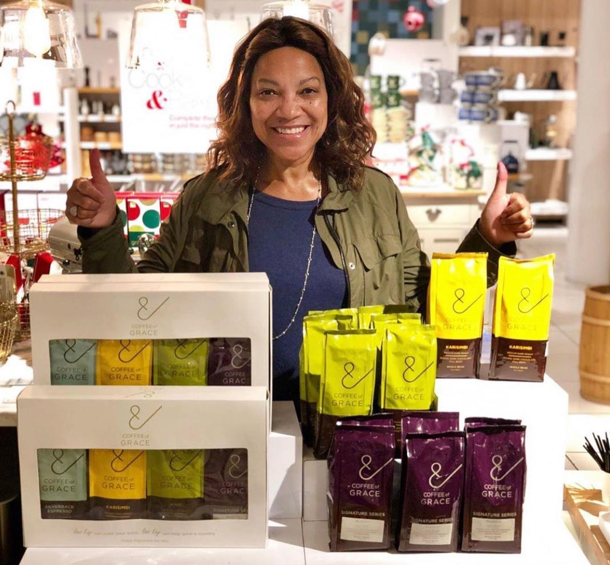 Grace Hightower gives two thumbs up while posing with her Coffee of Grace specialty coffee
