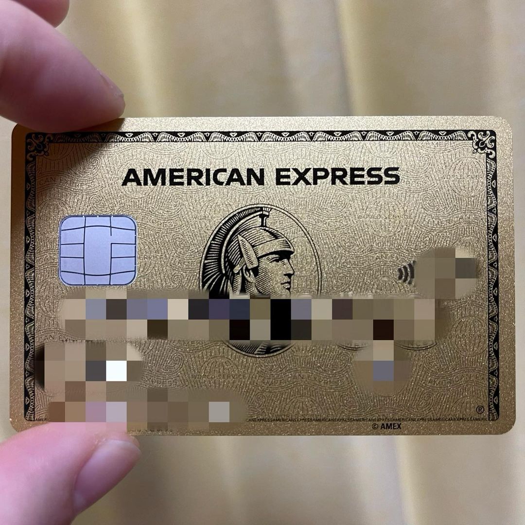 Two left fingers holding American Express Platinum Card, with certain details pixelated