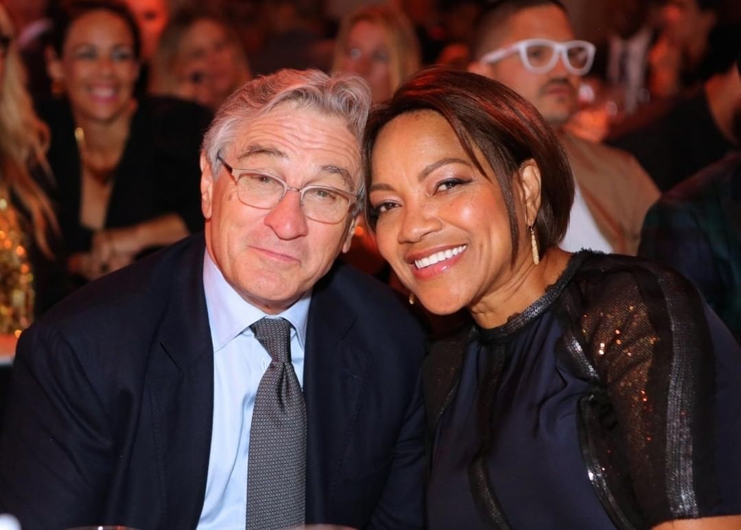 Robert De Niro in suit and tie and Grace Hightower in black dress amidst the crowd