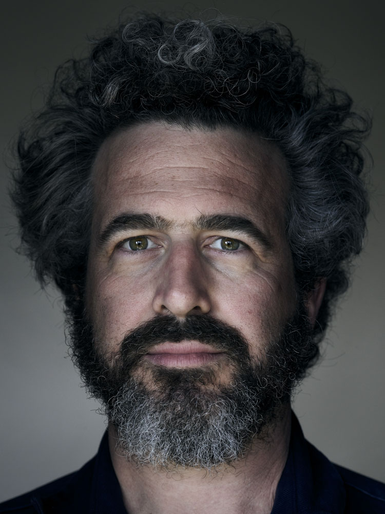 Ethan Sandler headshot gave a closer look at his beard, mustache, and messy curly hair