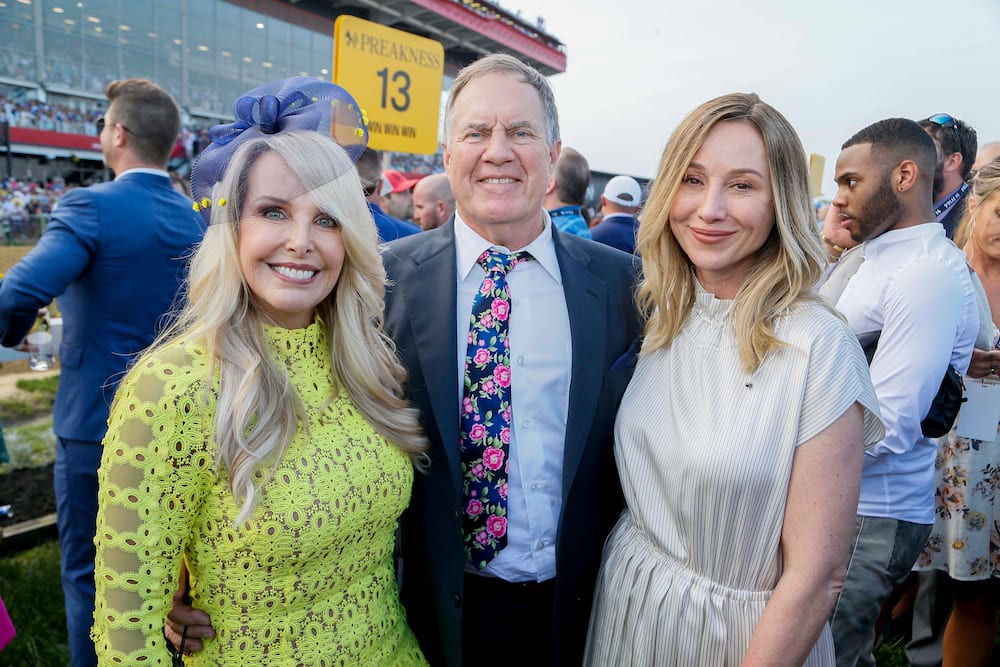 Debby clarke belichick standing with husband and daughter in a green dress
