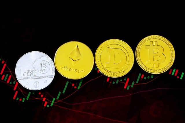 Ethereum, Dogecoin, and Bitcoin on top of a trading chart