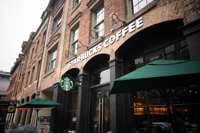 Façade of Starbucks Coffee branch at the ground floor of a brick building