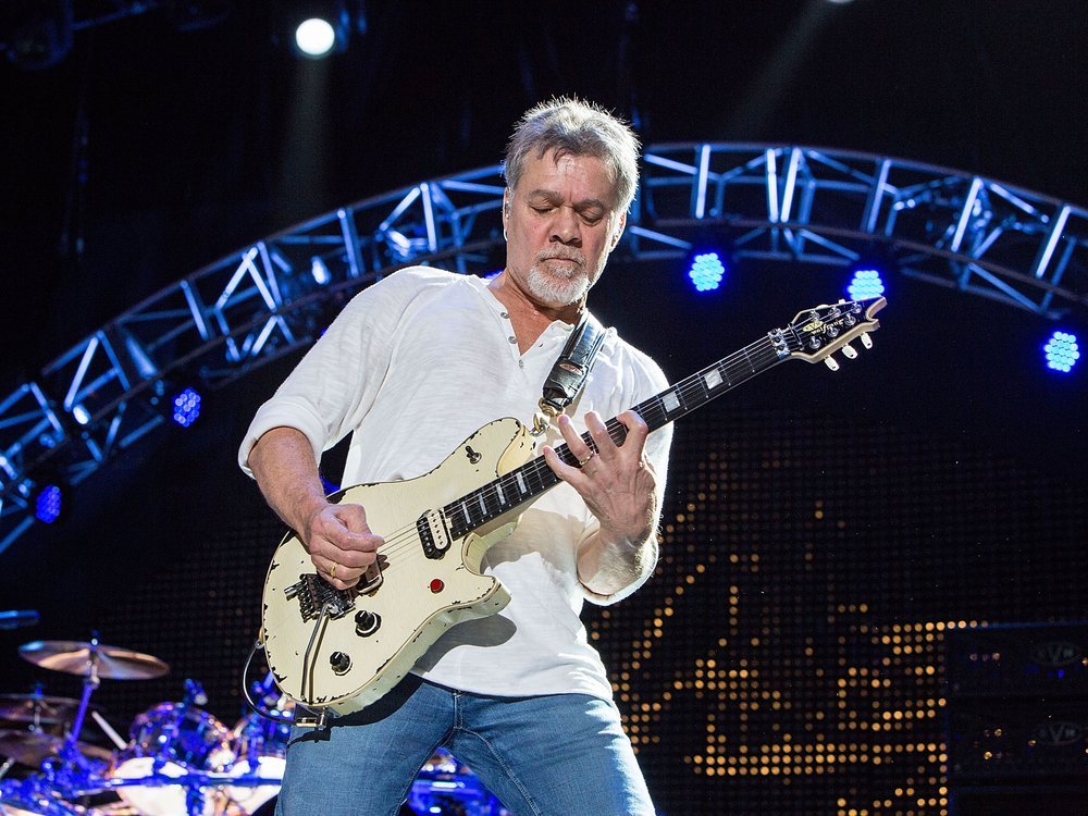 Guitarist Eddie Van Halen playing guitar on stage in one of his concert