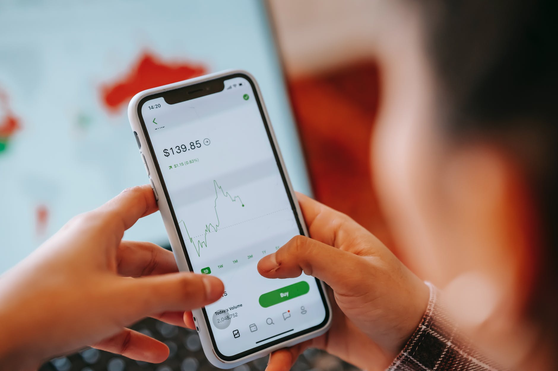 Hands holding a phone with crypto price reports