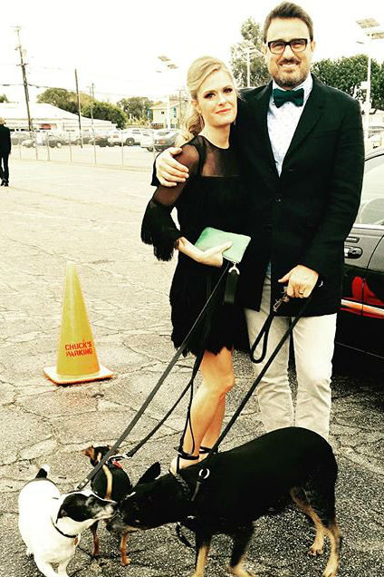 Ben koldyke with maggie lawson in a black dress with their three dogs at a parking spot