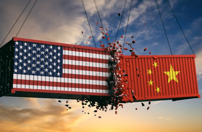 Two container crates colliding with flags of China & USA symbolizing each one