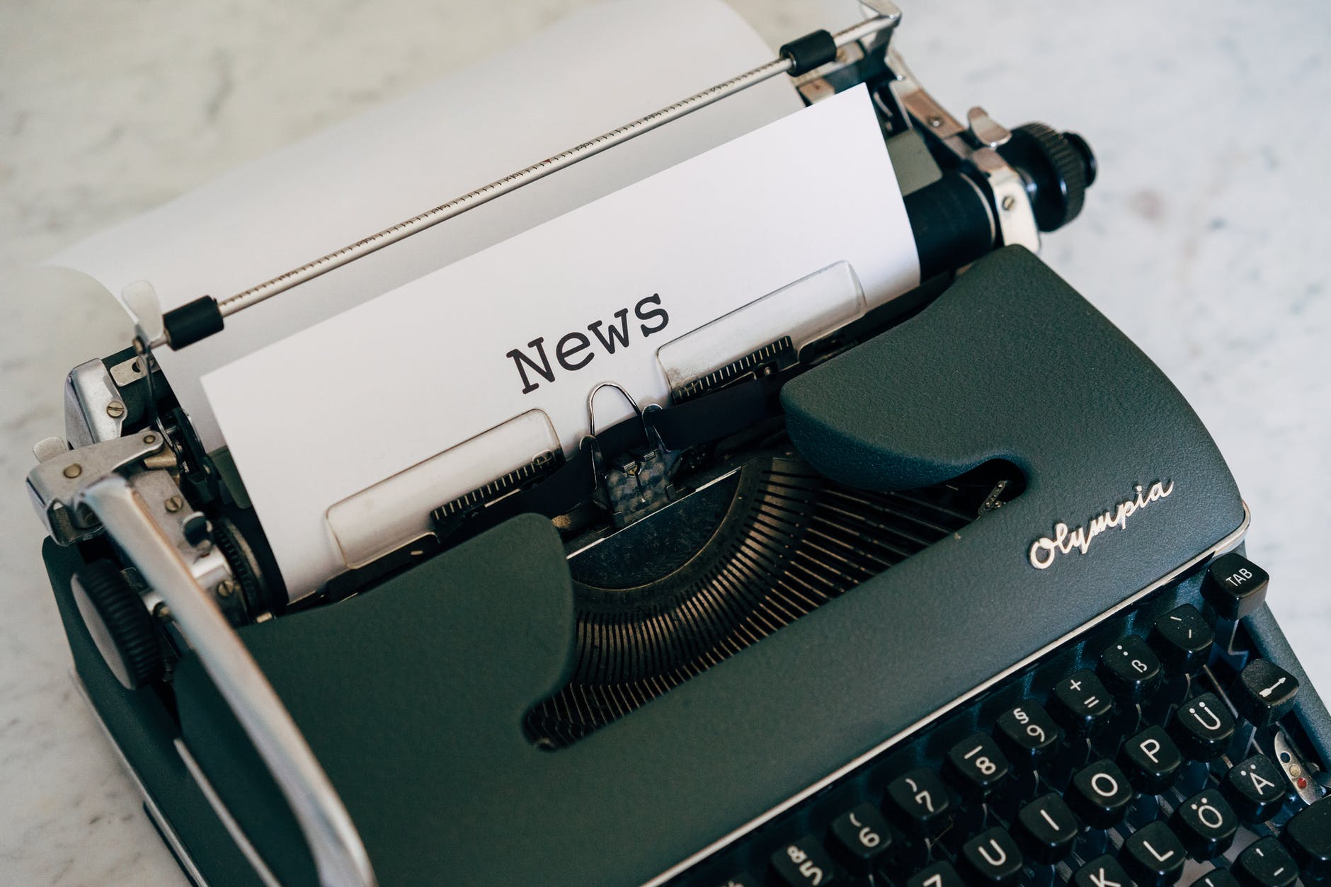 Typewriter with the word news typed on it