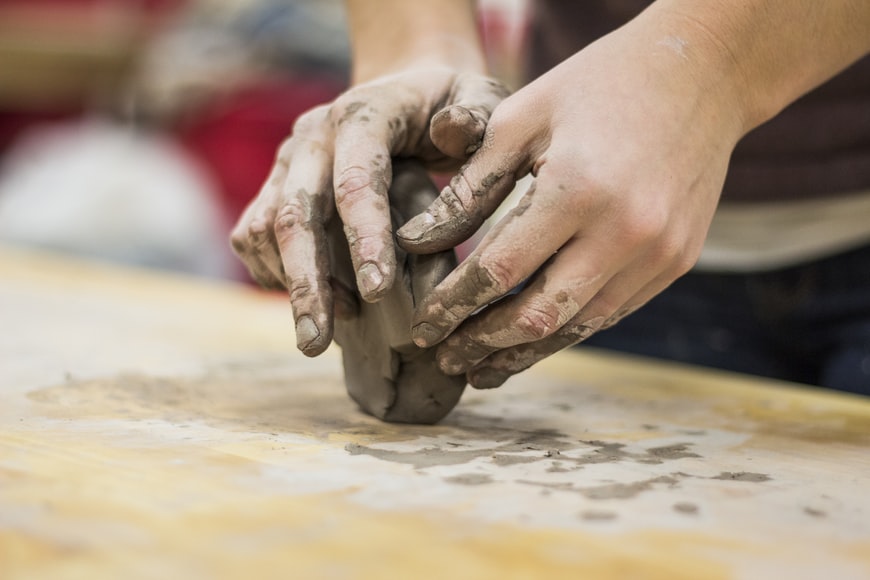 A pair of hands molding a clay