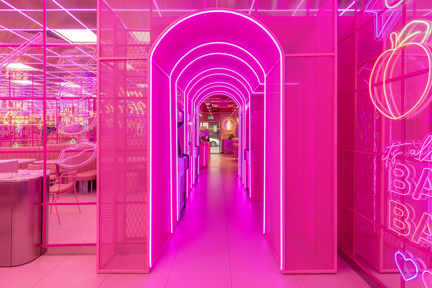 Pink hallway lined with pink neon lights and neon lights on wall