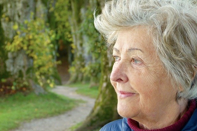 Old gray-haired woman with a closed mouth smile