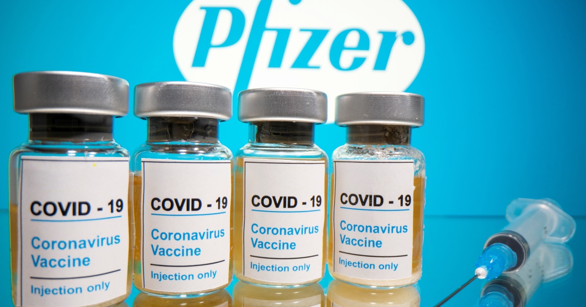 Four bottles labelled Covid-19 coronavirus vaccine alongside an injection syringe and Pfizer logo