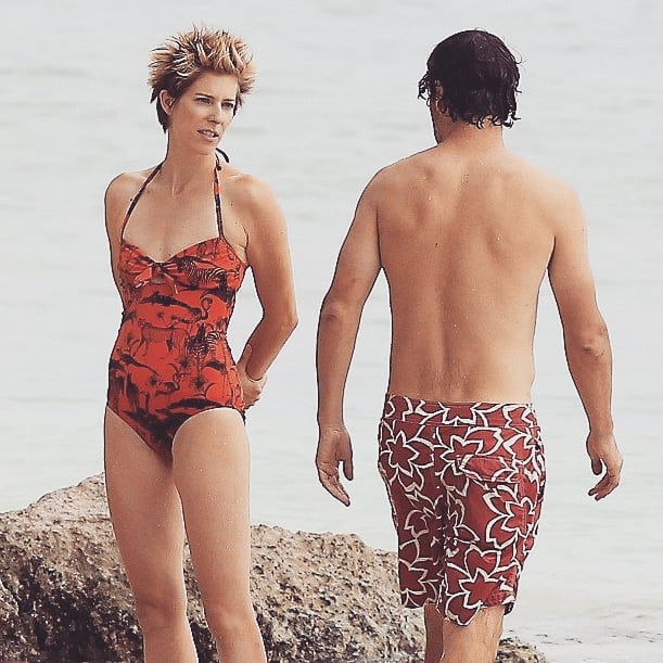 Gael Anderson in red printed one-piece swimsuit and her trademark spiky hair at the beach with Andrew Lincoln