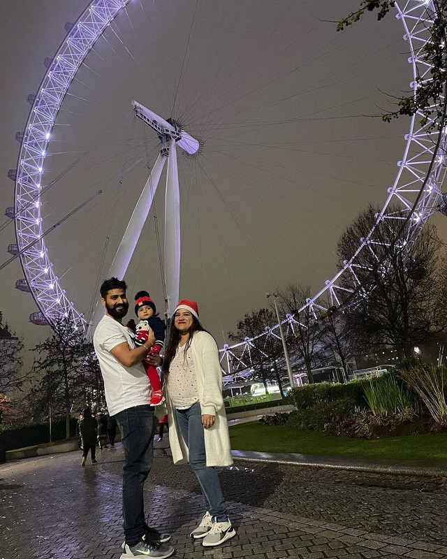 Indian couple and their child visiting the London Eye at night