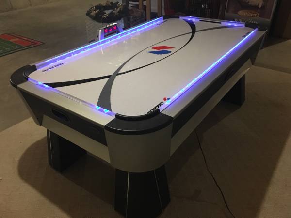 Sportcraft 7 Ft Turbo Air Hockey Table when its blue lights turned on. 