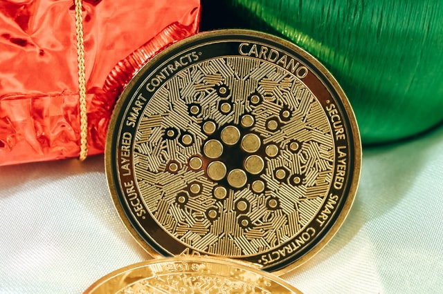 A single Cardano coin, with the words ‘secure layered smart contracts’ etched on it