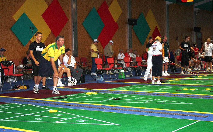 The player pushes the discs towards the target to score using shuffleboard cue