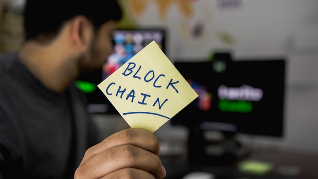 Male holds paper with the words ‘block chain’ while crypto mining