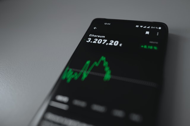 Smartphone showing graph with green lines and Ethereum price at 3.207,20 euros