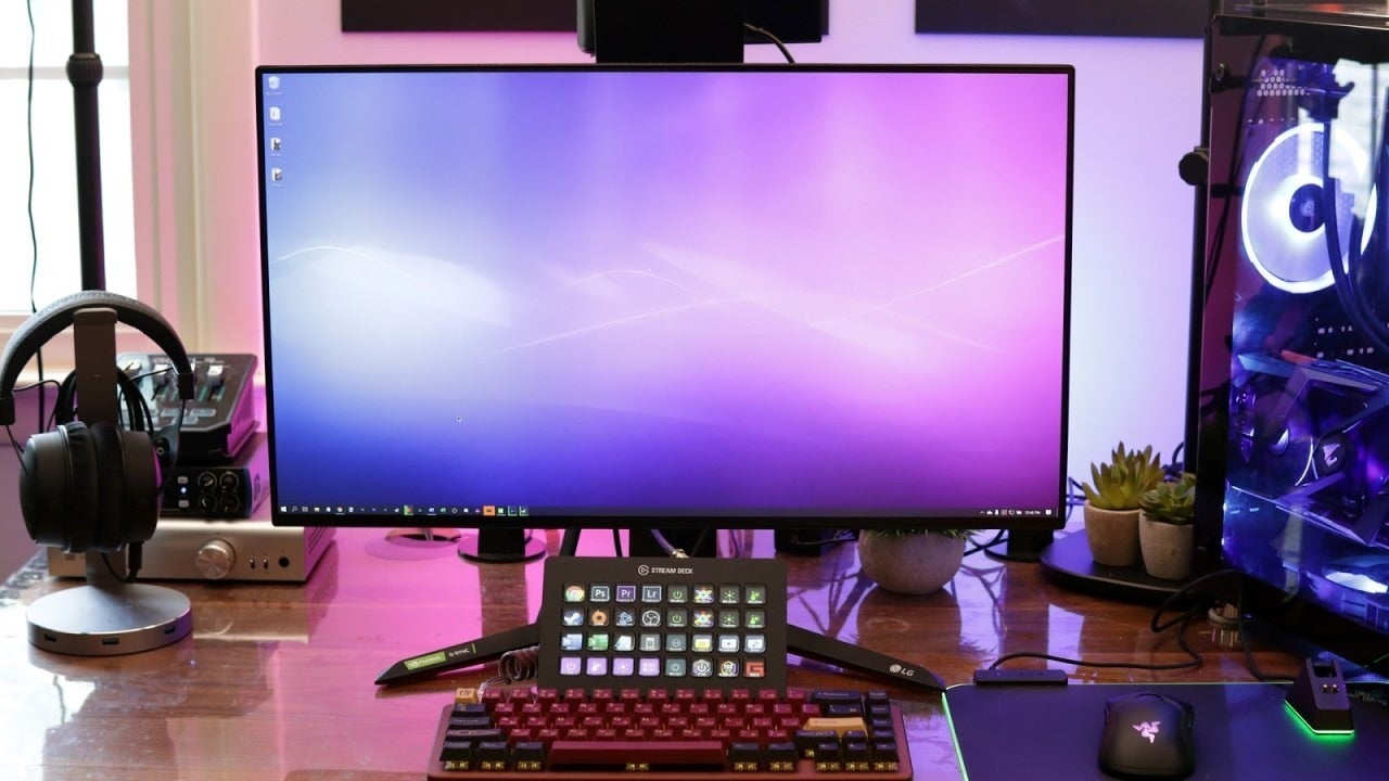 A purple computer screen with a mouse and headphones on the handlebars. A keyboard with red and black buttons is nearby.