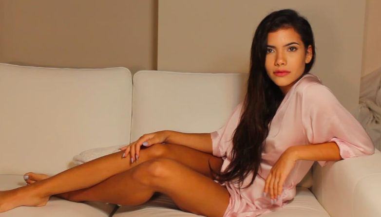 Sohvi Rodriguez looks great while she is posing on a sofa wearing a pink pajama
