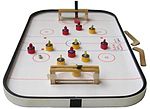 A tabletop rod hockey game resembles a white board