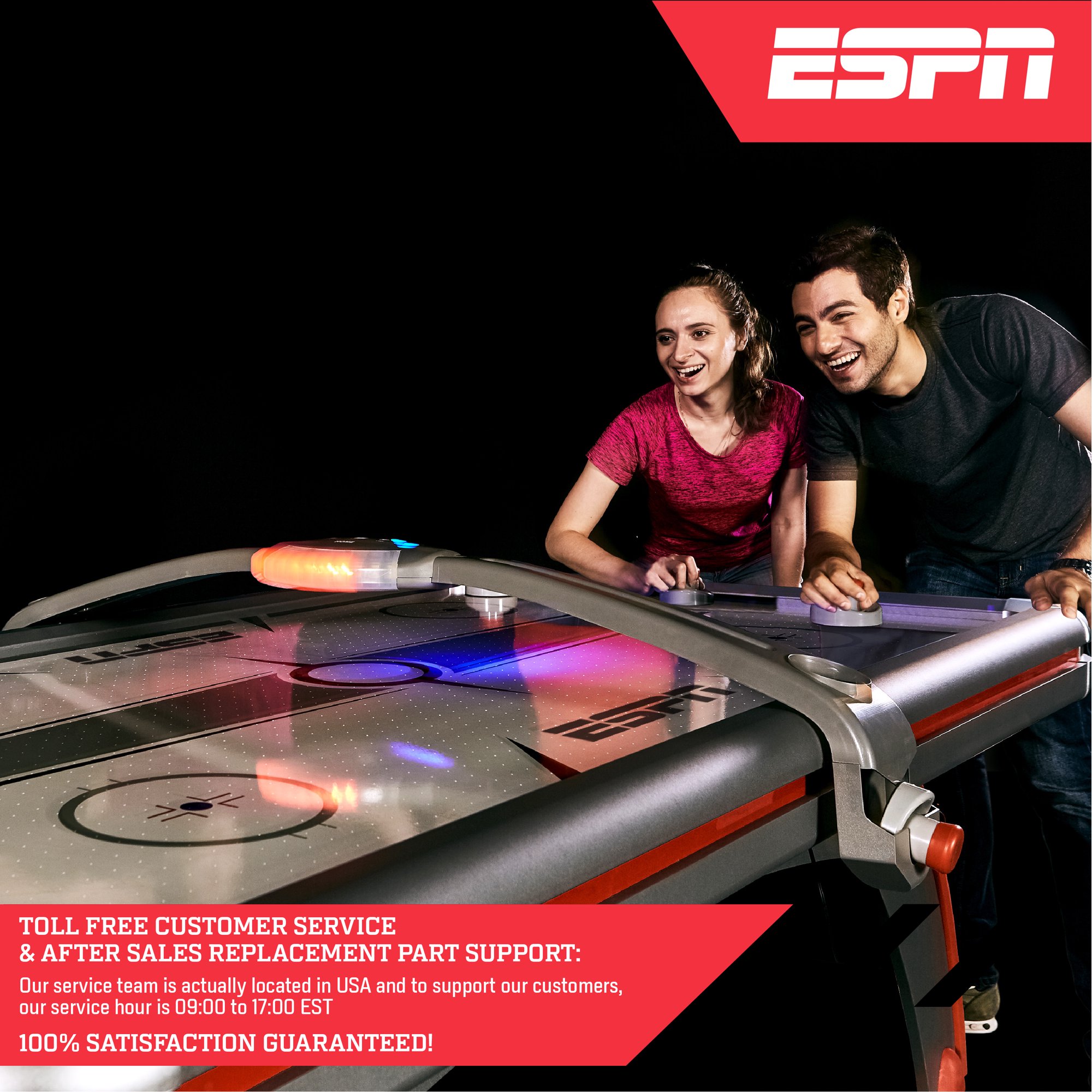 One pair of players smiling while playing ESPN hockey table in a dark room