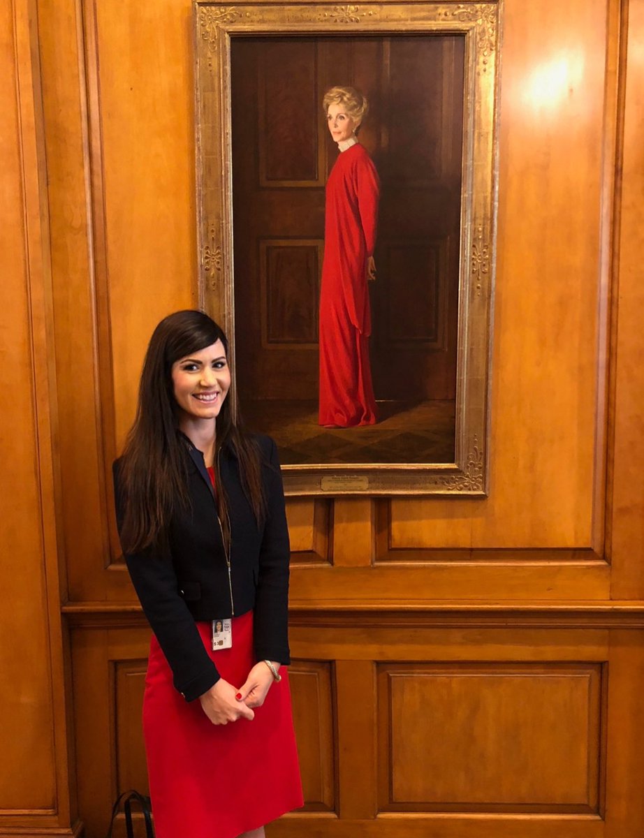 Amanda Milius beside the lady painting both are wearing red dress