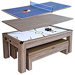 An air hockey table made with driftwood that can swap out the table tennis top and dining surface