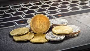 Above the laptop, there are gold bitcoins surrounded by more bitcoin