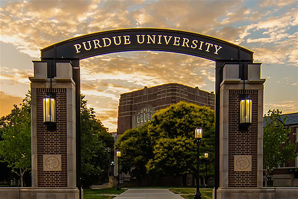 The main entrance of purdue university with a brick arc and the university name on the arc