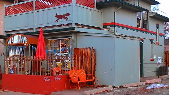 Outside look of weathervane cafe with blue walls and orange chairs