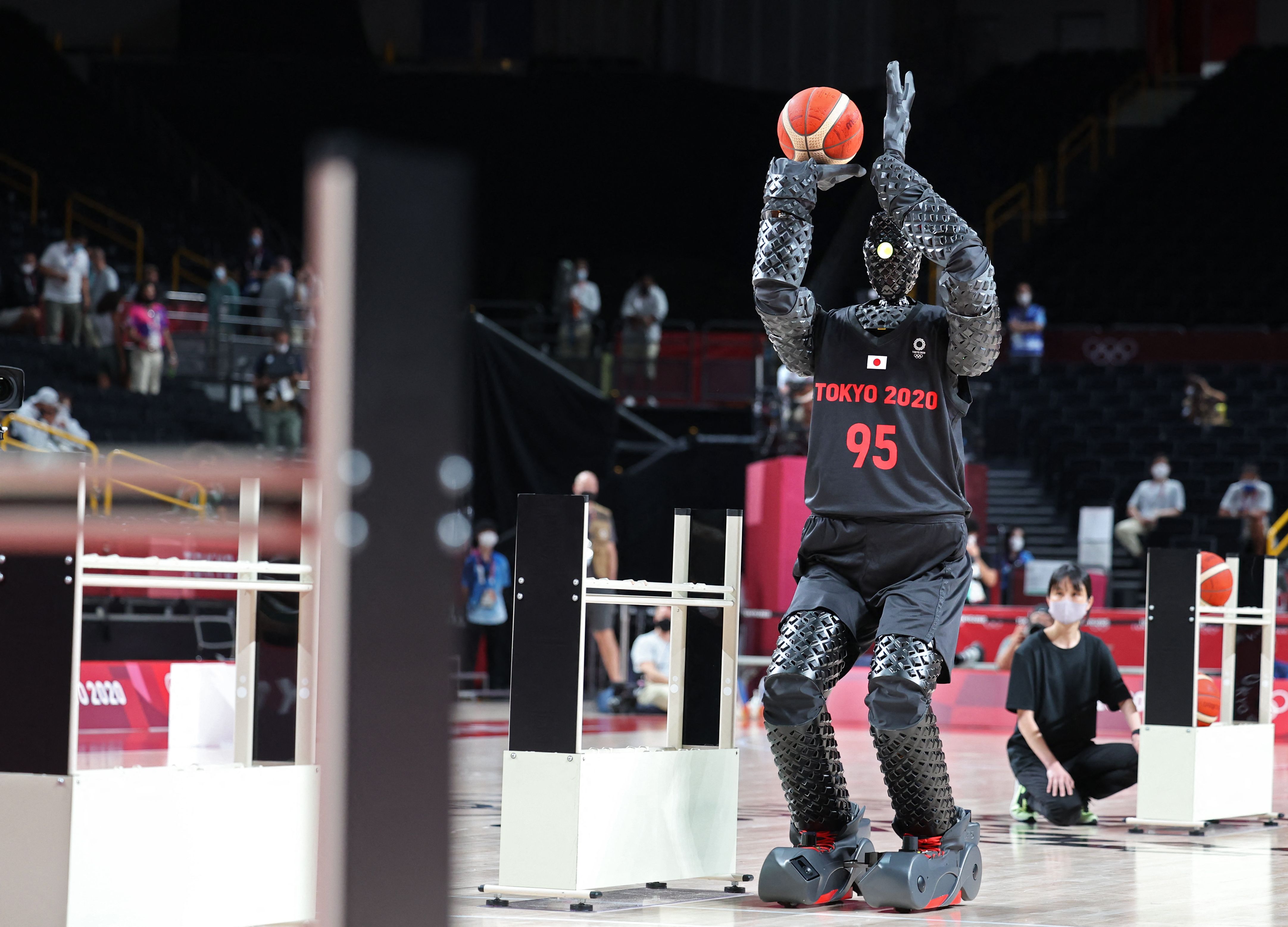 CUE robot playing basketball in the stadium making free throws