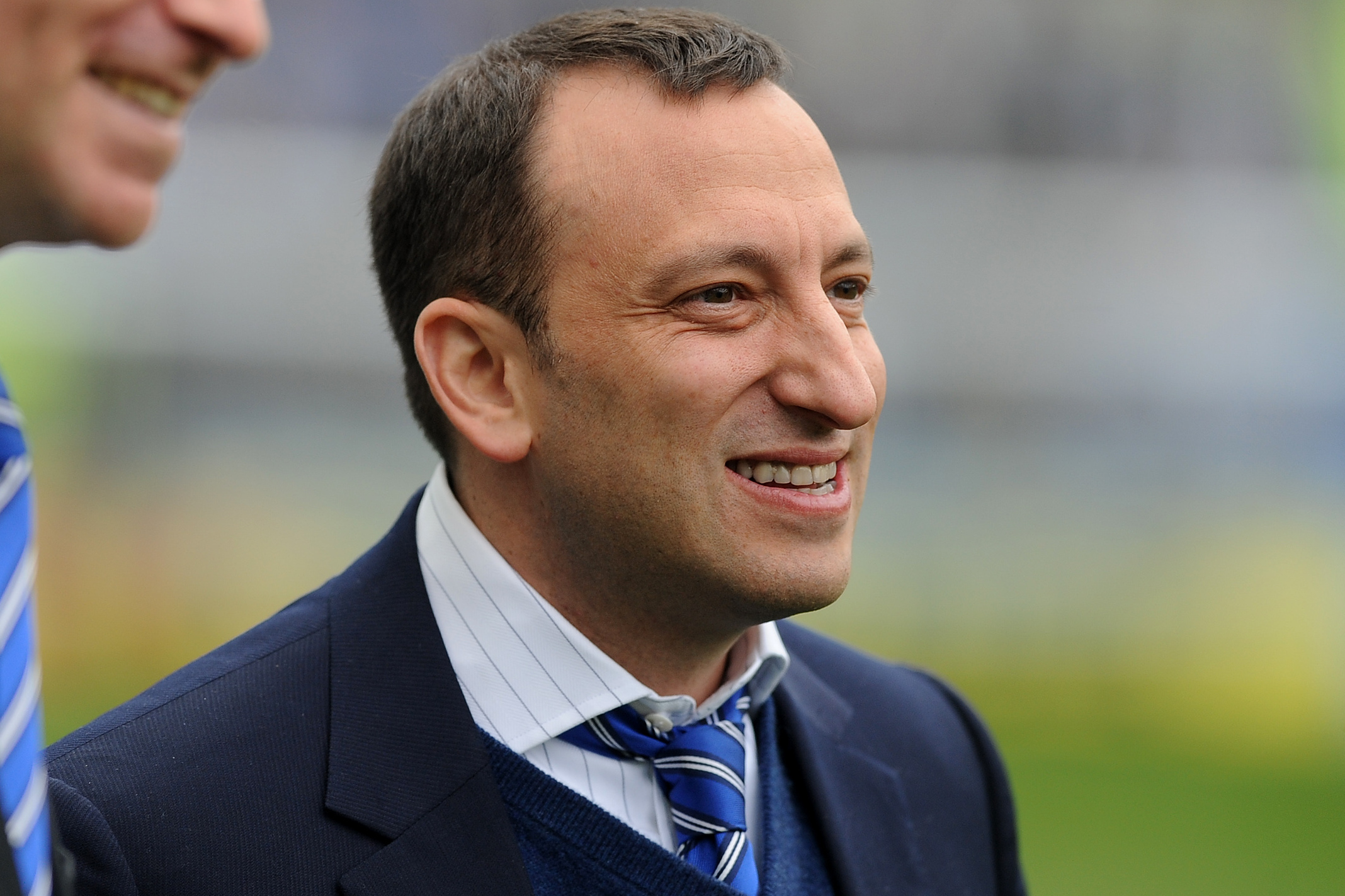 Tony Bloom wearing a blue suit on a white shirt and laughing