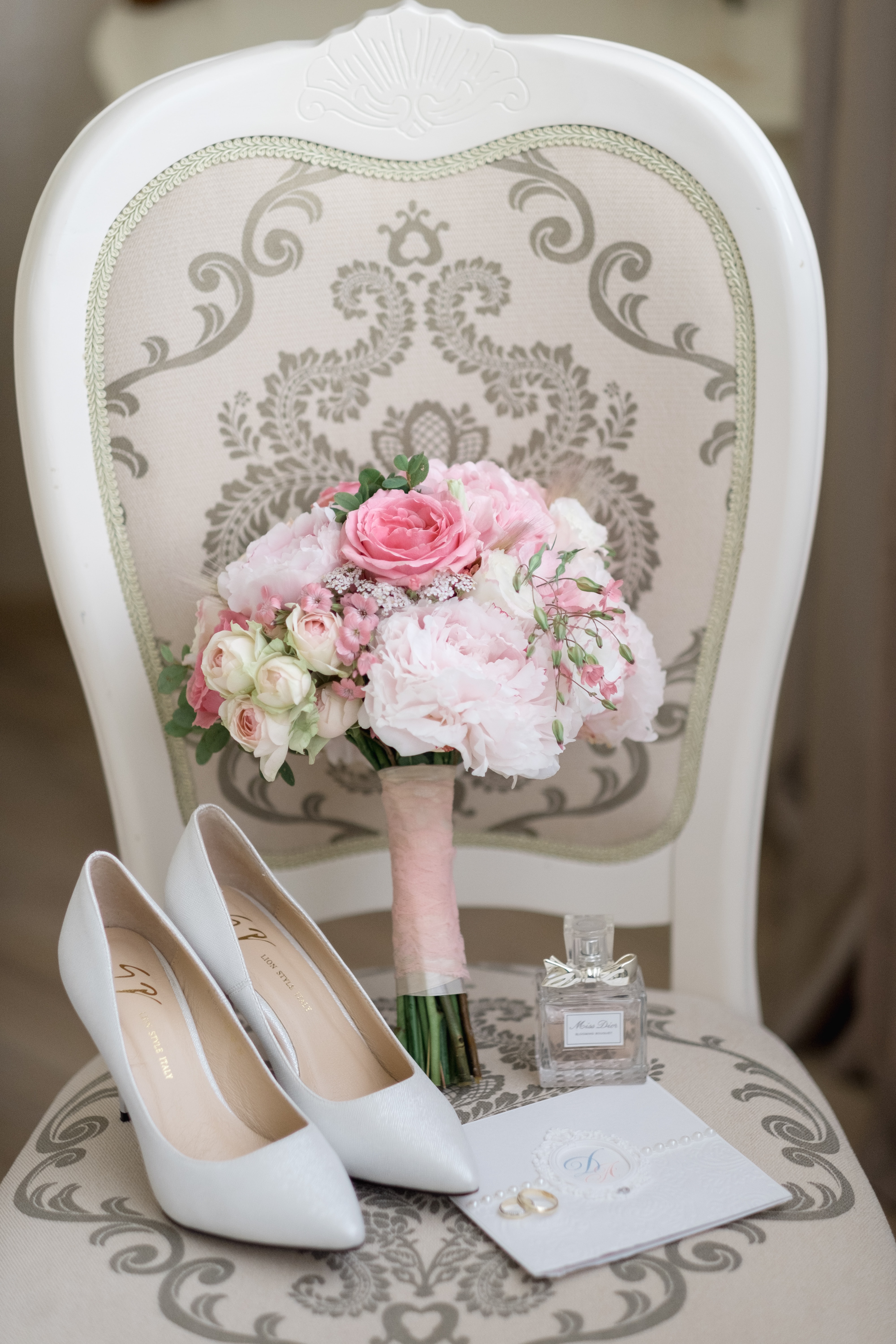 White wedding shoes placed on a chair along with flowers