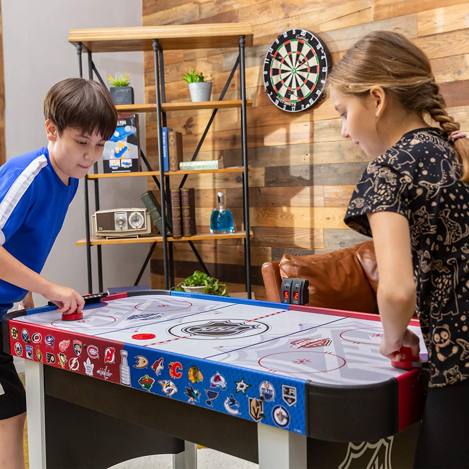 Two kids playing on a Mid-Size NHL Rush Indoor Hover Hockey Table