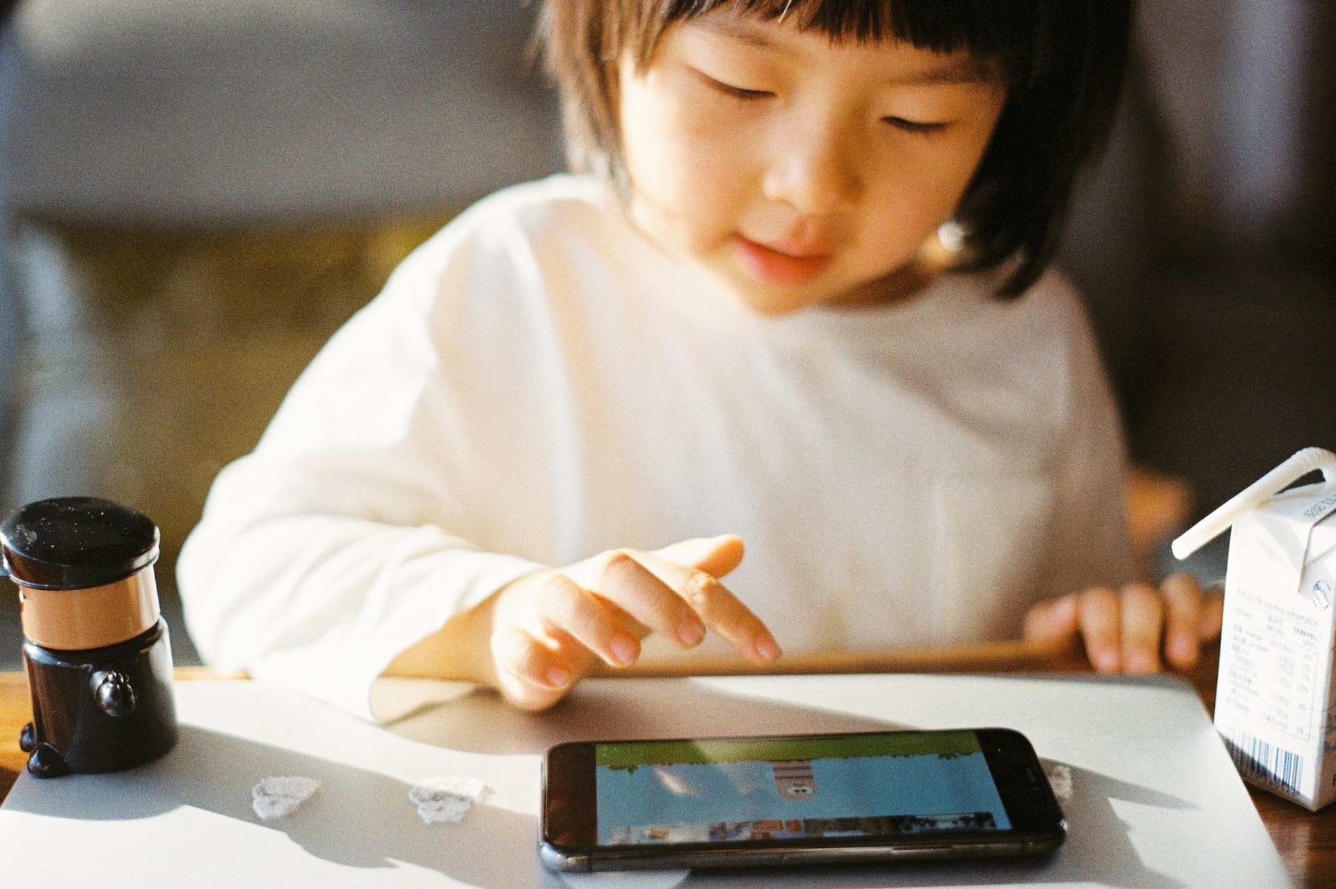 A little girl playing an online game on her tablet
