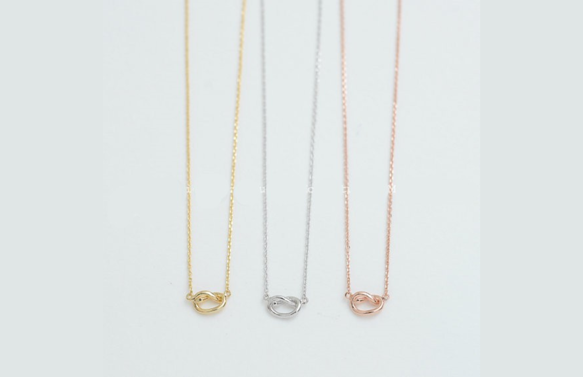 Gold, silver, and bronze knot necklaces