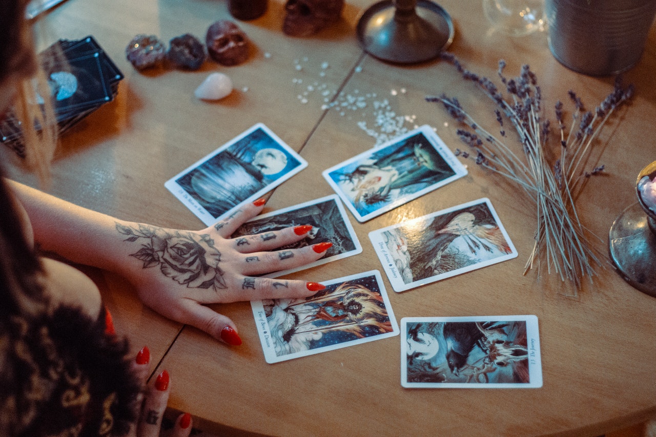 A Woman Reading Tarot Cards On Table