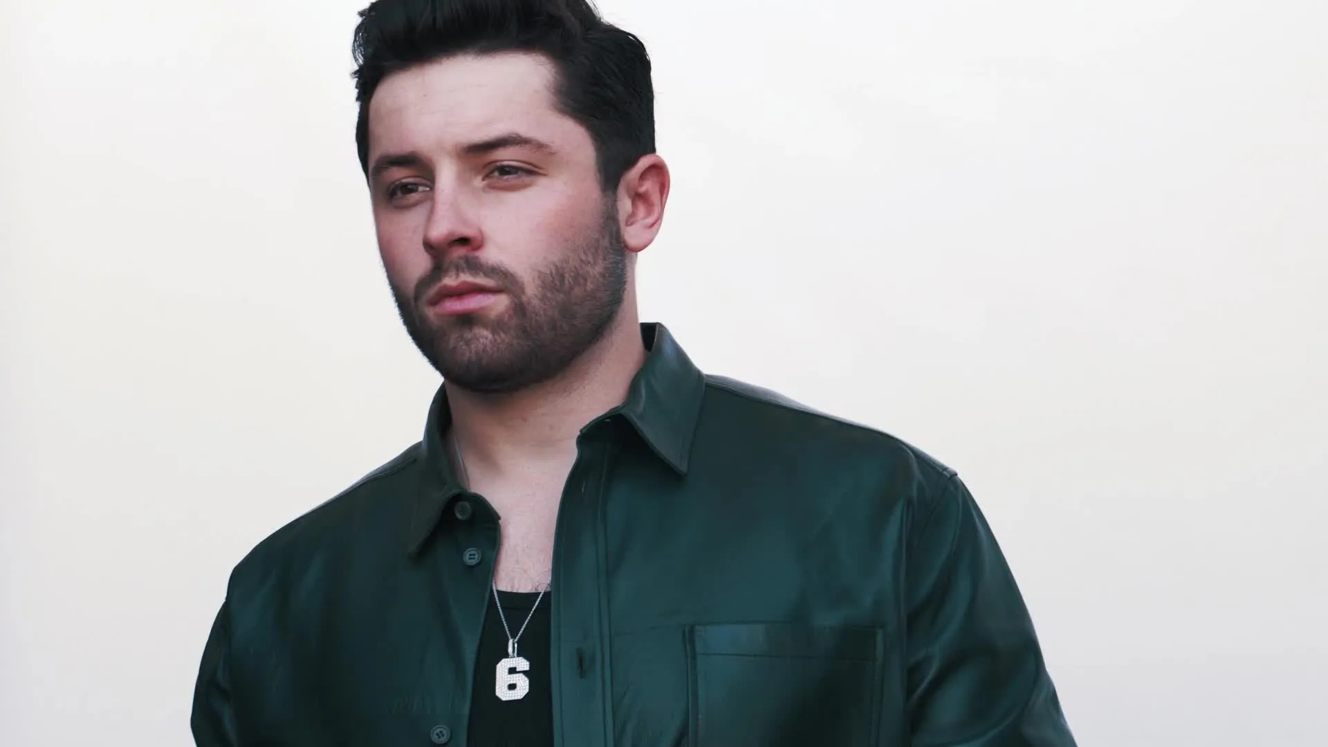 Baker Mayfield Is Wearing A Green Colored Shirt And A No. 6 Necklace