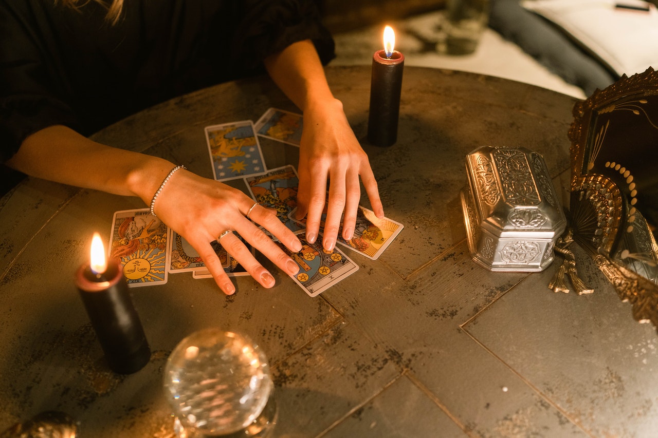 Hands Touching the Tarot Cards on the Table