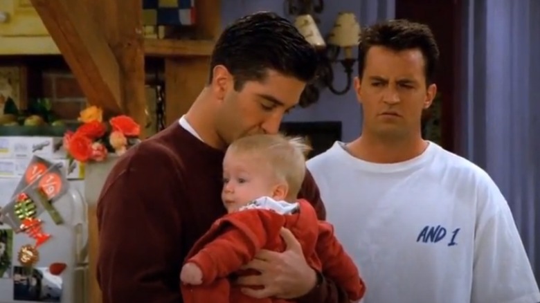 David Schwimmer holding young Charles Thomas Allen and kissing his forehead in Friends