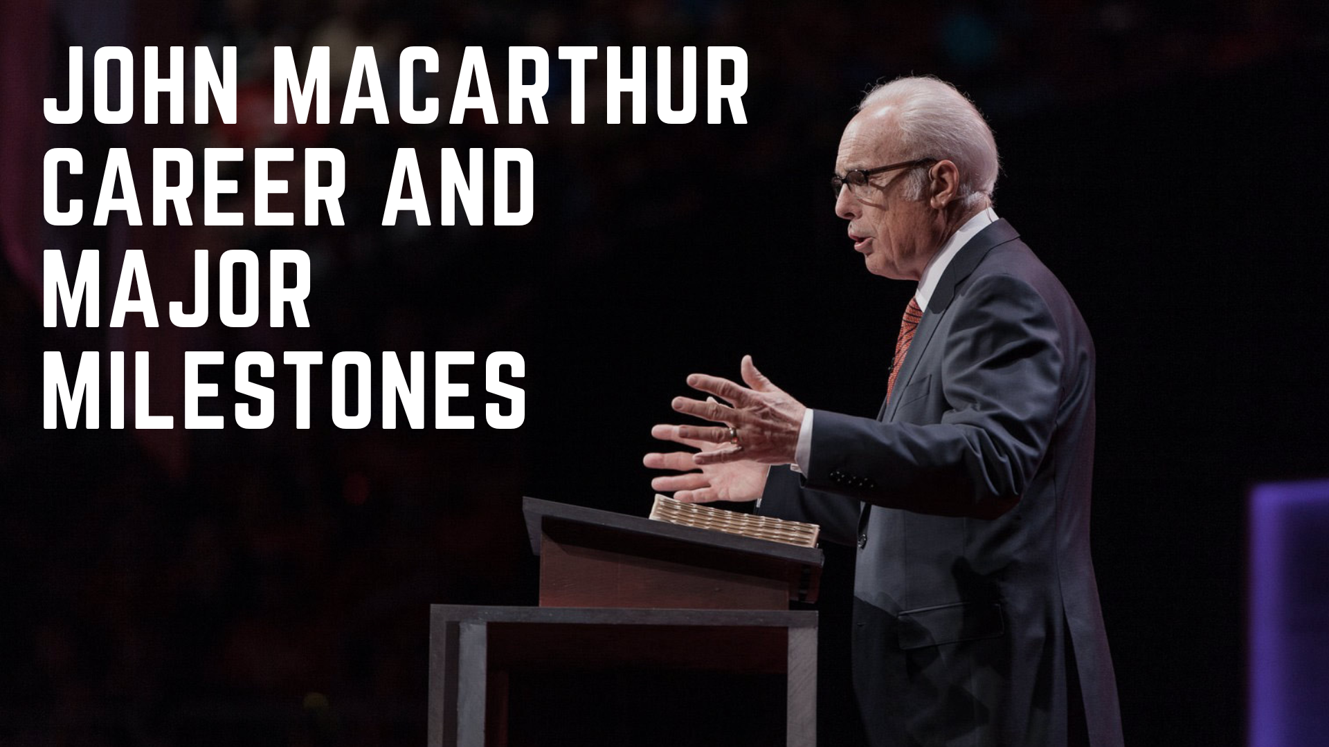 John Macarthur standing in front of a podium with a Bible